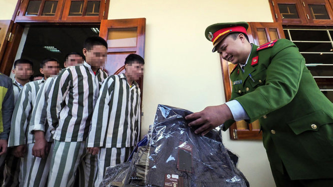 Các phạm nhân xếp hàng để nhận một bộ quần áo mới trước khi được ra tù