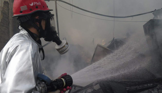 Do trong kho chứa nơi xảy ra vụ cháy có nhiều khói độc nên lực lượng PCCC phải dùng mặt nạ để chống độc - Ảnh: Quang Thế