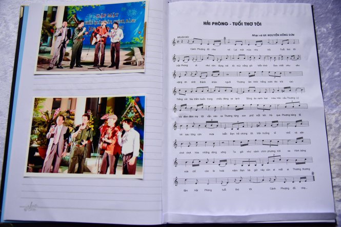 Bài hát viết về quê hương cùng những hình ảnh lưu niệm cùng NSƯT Quang Lý được Thiếu tướng Nguyễn Hồng Sơn dán vào trong sổ tang - Ảnh: HỮU THUẬN