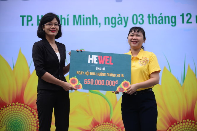 Bà Nguyễn Thị Lan – đại diện sản phẩm bảo vệ gan Hewel (Công ty Cổ phần dược phẩm ECO) trao bảng tượng trưng ủng hộ ngày hội và học bổng “Ước mơ của Thúy” 650 triệu đồng - Ảnh: QUANG ĐỊNH