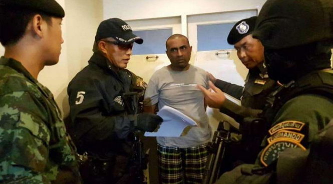 Nghi can Abdul Rehman (giữa) sau khi bị bắt - Ảnh: AFP