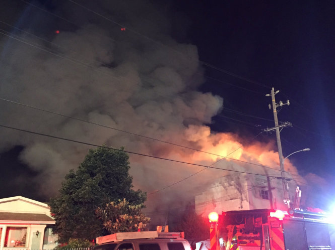 Ngọn lửa bốc lên từ nóc nhà kho sau khi trần nhà bị sập - Ảnh: Reuters