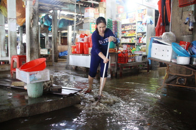 Nước lũ trên sông Bồ lên nhanh tràn vào chợ Hương Cần (xã Hương Toàn, thị xã Hương Trà) khiến nhiều tiểu thương ở đây không kịp di chuyển hàng hóa - Ảnh: NHẬT LINH