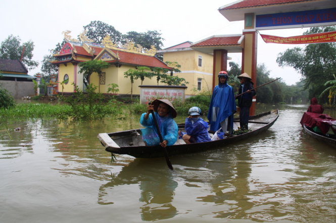 Nước lũ trên sông Bồ lên nhanh khiến tuyến đường qua thôn Giáp Kiền (xã Hương Toàn, thị xã Hương Trà) chìm trong biển nước - Ảnh: NHẬT LINH