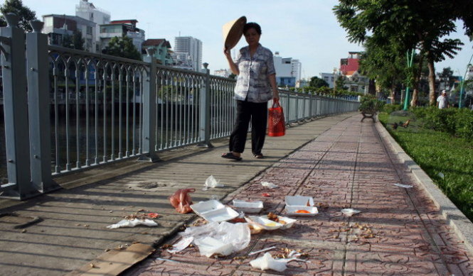 Hiện mức phạt đối với hành vi xả rác trên đường phố là 300.000-400.000 đồng, nhưng rất ít người bị xử
phạt. Trong ảnh: vứt rác bừa bãi ở đường ven kênh Nhiêu Lộc - Thị Nghè (TP.HCM) - Ảnh: H.Khoa