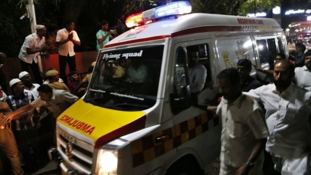 Nhiều người chạy theo xe cứu thương khi chiếc xe chở thi thể bà rời bệnh viện - Ảnh: AP