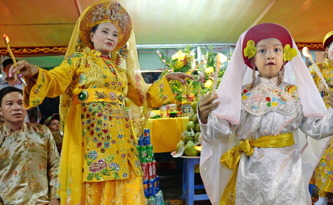 Đồng thầy Đặng Thị Nữ (Huế) cùng tân đồng nhí Đăng Đinh Hiền (7 tuổi) hầu giá Bà Bạch Ba Công Chúa trên thuyền trước điện Huệ Nam