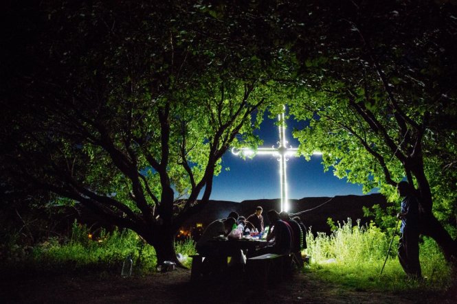 Dân làng ở Bagaran, Armenia, dã ngoại vào ban đêm dưới những tán cây và một cây thánh giá khổng lồ tỏa sáng