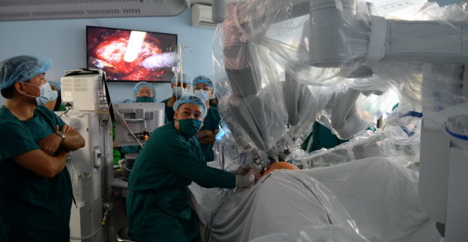 Các bác sĩ theo dõi ca mổ nội soi bằng robot qua màn hình ti vi - Ảnh: Hữu Khoa