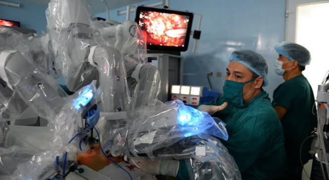Bác sĩ Bệnh viện Bình Dân đang điều khiển robot phẫu thuật cắt tuyến tiền liệt cho một bệnh nhân ung thư tuyến tiền liệt chiều 10-12 - Ảnh: Hữu Khoa