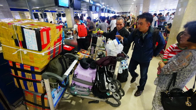 Sân bay Tân Sơn Nhất dịp tết hay quá tải là không tránh khỏi. Nhiều hãng hàng không có nguy cơ không
được cấp phép tăng chuyến dù đã bán vé. Trong ảnh: hành khách làm thủ tục lên máy bay tại sân bay
Tân Sơn Nhất - Ảnh: Quang Định