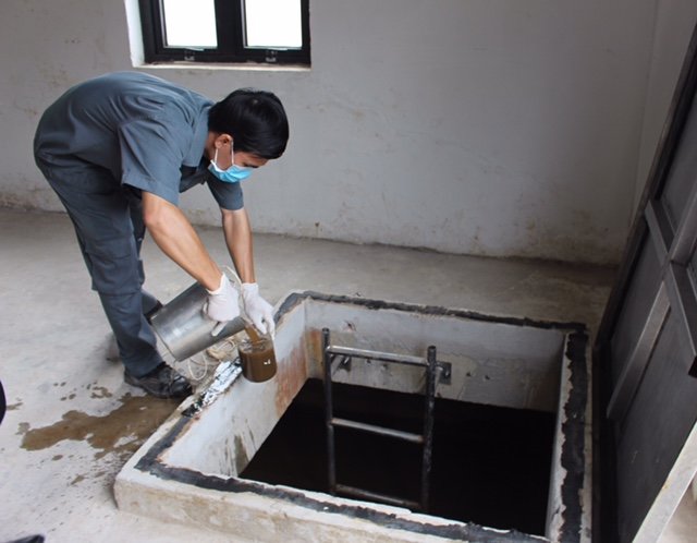 Nhân viên kỹ thuật Nguyễn Ngọc Ánh lấy mẫu kiểm tra độ lắng của nước thải ở khu vực bể vi sinh - Ảnh: K.THU