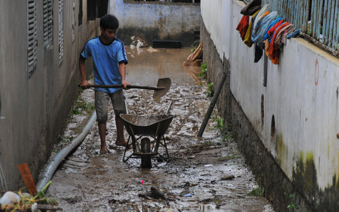 Người dân thành phố Nha Trang dọn dẹp bùn đất khi nước rút - Ảnh: Thanh Trúc