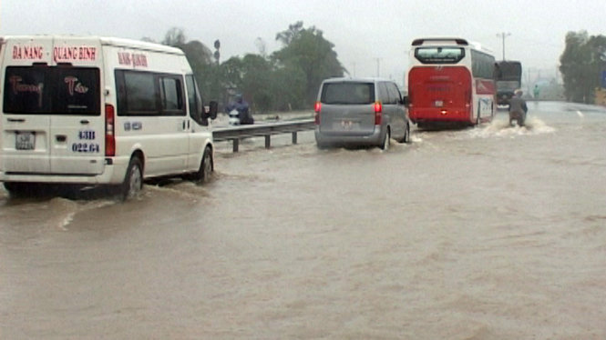 Nước lụt tràn qua quốc lộ 1 A đoạn xã Lộc Trì, huyện Phú Lộc trong chiều 13-12 - Ảnh: CÔNG TUYỂN