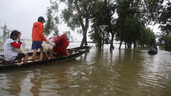 Người dân ở xã Hương Toàn (thị xã Hương Trà) phải dùng xuồng để đi lại do nước lũ ngập sâu - Ảnh: NHẬT LINH