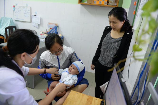 Người dân đưa con khám bệnh tại Trung tâm Y tế dự phòng Bình Chiểu, Q.Thủ Đức, TP.HCM - Ảnh: HỮU KHOA