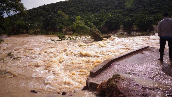 Cây cầu bê tông tại xã Đinh Lạc bị lũ cuốn trôi mất một nửa - Ảnh: QUỐC BẢO