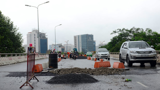 Các công nhân đang sửa đường tại công trình sửa chữa cầu vượt Nguyễn Hữu Cảnh (Q.Bình Thạnh)