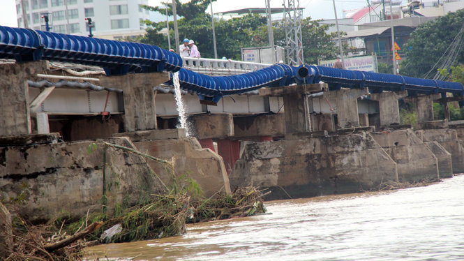 Hơn 40m ống dẫn nước sinh hoạt về phía Bắc Nha Trang ngang qua cầu Xóm Bóng bị đứt gãy do trụ đỡ bị lũ cuốn trôi - Ảnh: TRUNG TÂN