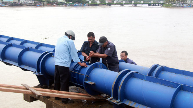 Các công nhân Công ty cổ phần cấp thoát nước Khánh Hòa đang khắc phục, gia cố để cấp nước tạm thời cho các hộ dân - Ảnh: TRUNG TÂN