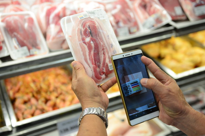 Chỉ cần cài app vào điện thoại thông minh, khách hàng có thể truy xuất nguồn gốc thịt heo khi mua tại siêu thị. Ảnh: QUANG ĐỊNH