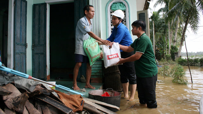 Đại diện báo Tuổi Trẻ và Tỉnh đoàn Bình Định trao quà cứu trợ tận nhà cho một hộ dân ở xã Hoài Thanh Tây (huyện Hoài Nhơn) - Ảnh: ĐẮC PHỤNG