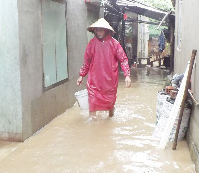 Trong cơn mưa lũ ngày 16-12, trưởng thôn Nguyễn Văn Luân - người dẫn đầu nhóm ứng cứu các cô trò Trường mẫu giáo An Hiệp - cần mẫn dọn dẹp nhà cửa chống lũ - Ảnh: KIM THỦY