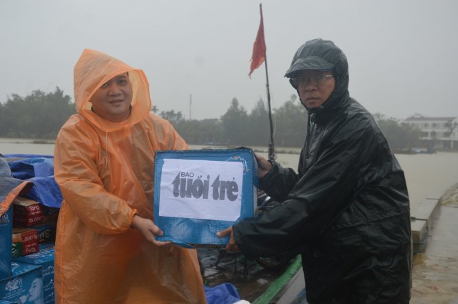 Ông Nguyễn Thế Hùng (phải) và đại diện báo Tuổi Trẻ vận chuyển quà hỗ trợ người dân vùng lũ - Ảnh: Thanh Ba