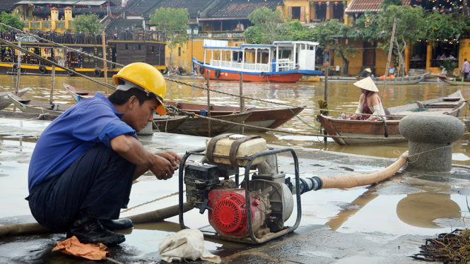 Máy bơm hút nước từ dưới sông Hoài lên xịt bùn đất - Ảnh: Thanh Ba