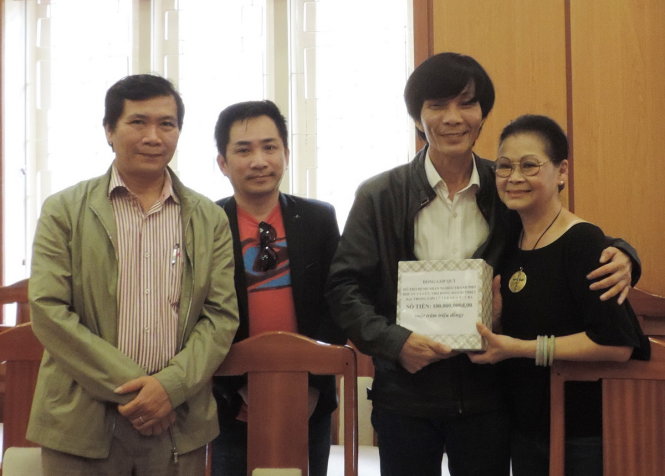 Ca sĩ Khánh Ly (bìa phải) trao tặng số tiền bán vé cho ông Nguyễn Sự - nguyên Bí thư Thành ủy Hội An - để chuyển đến bà con vùng lũ - Ảnh: HOÀNG DUY