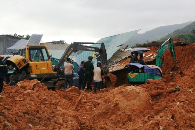Lực lượng cứu nạn đang đào đất đá để tìm kiếm hai mẹ con chị Hoa, em Sang dưới ngôi nhà đã bị sập, chôn sâu dưới đất đá - Ảnh: Phan Sông Ngân