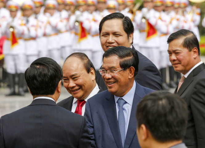 Thủ tướng Nguyễn Xuân Phúc và Thủ tướng Hun Sen cười tươi chào thành viên hai đoàn tại lễ đón ở Phủ Chủ tịch sáng 20-12 - Ảnh Việt Dũng
