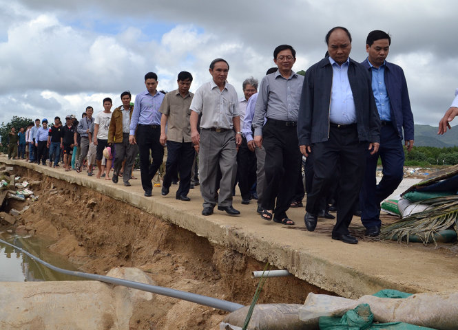 Thủ tướng động viên một người dân bị sập nhà ở xóm Xuân Cỏ, nơi có 11 căn nhà bị sập hoàn toàn, bốn căn nhà khác bị sập vách - Ảnh: DUY THANH