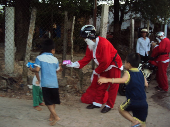 Nhóm các bạn trẻ thiện nguyện phát quà mùa Noel 2015 tại xóm trọ P.Chánh Nghĩa (TP Thủ Dầu Một, Bình Dương) - Ảnh: N.H.
