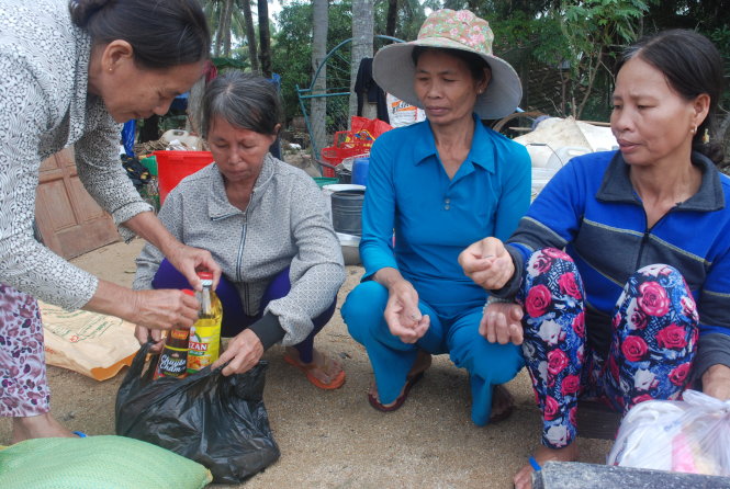 Bà con hàng xóm mang dầu ăn, gạo... tới giúp đỡ các gia đình bị lũ cuốn mất nhà tại thôn Lương Thái, xã Mỹ Chánh, huyện Phù Mỹ (Bình Định) - Ảnh: T.B.D.