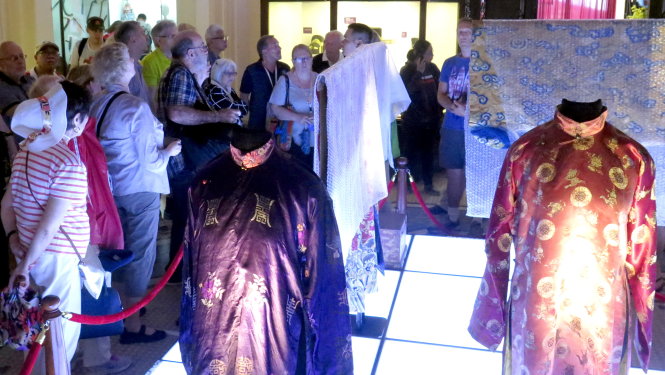 Nhiều du khách nước ngoài thích thú xem triển lãm Trang phục triều Nguyễn tại buổi khai mạc - Ảnh: L.Điền