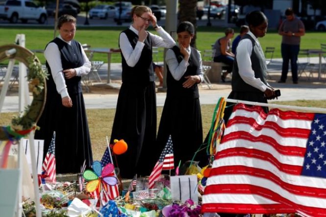 Người dân tới đặt hoa tưởng niệm các nạn nhân bị thảm sát tại hộp đêm ở Orlando, bang Florida, Mỹ - Ảnh: Reuters