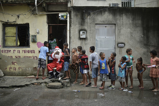 “Ông già Noel” phân phát quà cho trẻ em tại Rio de Janeiro (Brazil) - Ảnh: AFP/Getty