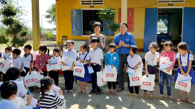 Anh Hà Duy Trung – phó bí thư Tỉnh đoàn Bình Định và chị Dương Phạm Thái Hằng – đại diện Công ty TNHH Nestlé VN – trao học bổng của và quà của Tuổi Trẻ cho học sinh Trường tiểu học số 2 Phước Sơn – Ảnh: DUY THANH