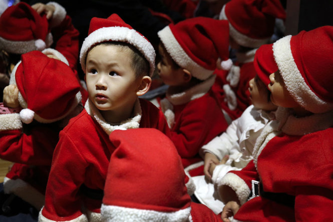 Các bé mẫu giáo được phụ huynh cho mặc trang phục “ông già Noel” trong một sự kiện được tổ chức vào dịp Giáng sinh tại Bắc Kinh (Trung Quốc) - Ảnh: AP