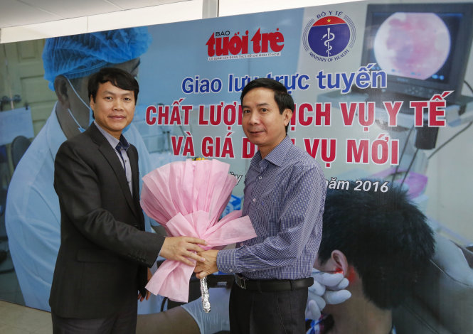 Đại diện báo Tuổi Trẻ tặng hoa ông Lê Văn Phúc (phải) - Ảnh: Việt Dũng