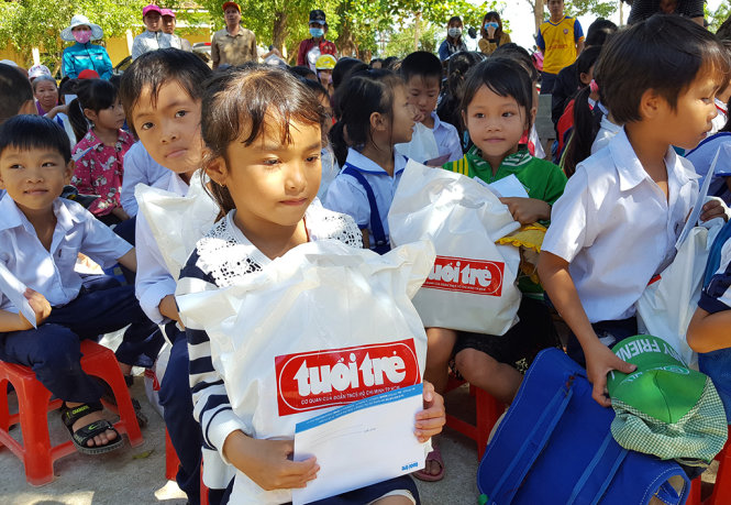 Học sinh Trường tiểu học số 2 Phước Sơn (xã Phước Sơn, huyện Tuy Phước, tỉnh Bình Định) nhận học bổng và quà của bạn đọc báo Tuổi Trẻ - Ảnh: DUY THANH