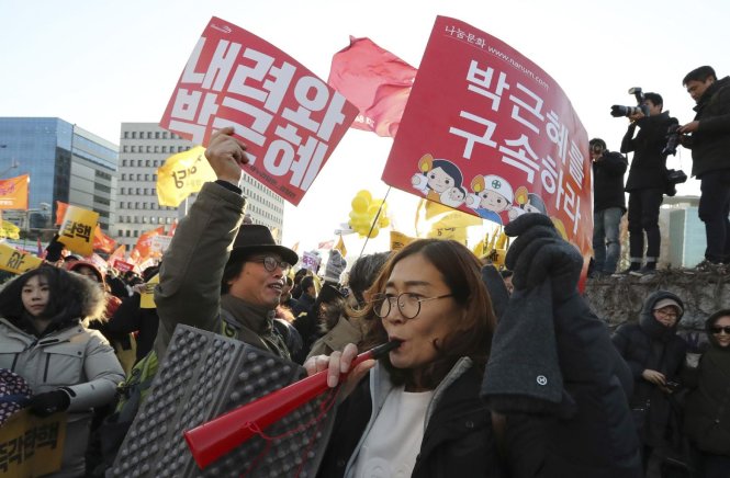 Người biểu tình ở bên ngoài tòa nhà quốc hội vui mừng sau khi nghe tin quốc hội đã thông qua dự luật luận tội bà Park Geun-hye hôm 9-12 - Ảnh: Reuters
