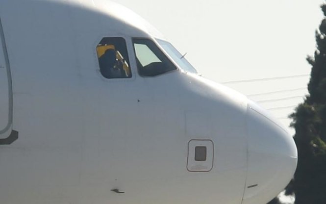 Một người được nhìn thấy trong khoang buồng lái máy bay bị không tặc - Ảnh: REUTERS