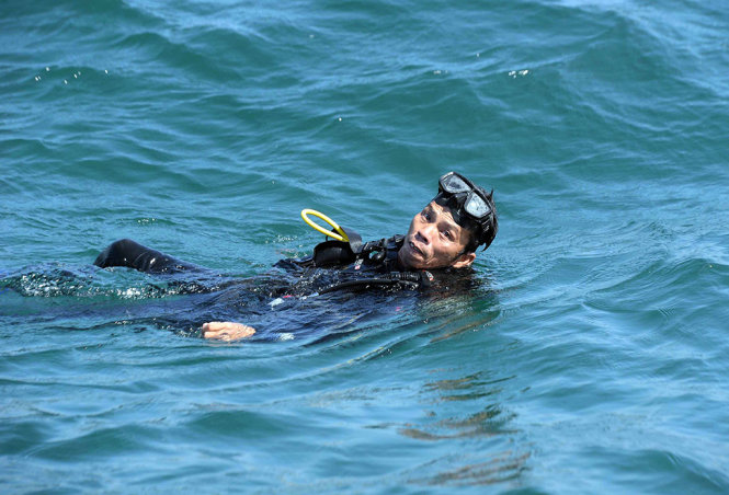Phút nghỉ ngơi trên biển của anh Nguyễn Linh Ngọc (nhân viên bảo tồn biển Phú Quốc) sau khi kiểm tra sức khỏe của san hô tại vườn ươm - Ảnh: HỮU KHOA