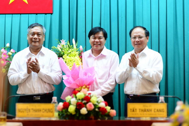 Phó bí thư thường trực Thành ủy TP.HCM Tất Thành Cang (ngoài cùng phải) và Bí thư Quận ủy Q. Tân Phú Nguyễn Thành Chung (ngoài cùng trái) tặng hoa chúc mừng ông Tăng Hữu Phong (giữa) - Ảnh: QUANG ĐỊNH