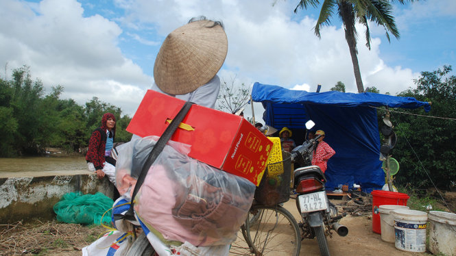 Người phụ nữ này đạp xe đạp từ làng của mình chở theo “hàng cứu trợ” mà gia đình quyên góp được để chia phần cho những hộ gia đình bị lũ đánh sập nhà cửa - Ảnh: B.D
