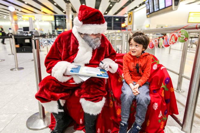 Hành khách nhí chia sẻ điều ước với ông già Noel Vietnam Airlines tại sân bay London Heathrow. Ảnh: Minh Ngọc