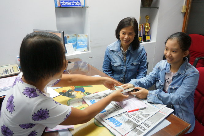 Em Trần Thị Hiếu Hậu (học sinh lớp 7 Trường Nguyễn Du, Q.1, TP.HCM) cùng mẹ đến báo Tuổi Trẻ gửi 1 triệu đồng cứu trợ đồng bào miền Trung bị lũ lụt - Ảnh: NGUYỄN CÔNG THÀNH