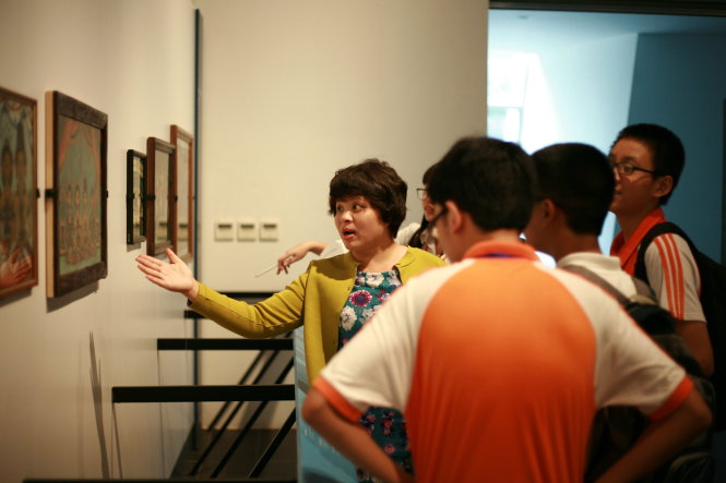 Cô Lê Thu chỉ dẫn cho học sinh về dòng tranh kính phổ biến ở Đông Nam Á trong tiết học về tính thống nhất trên đa dạng của văn hóa Đông Nam Á tại một bảo tàng - Ảnh: L.T.